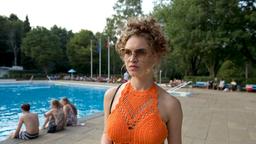 Nicoletta Caristeck (Yohanna Schwertfeger) trägt einen grell-orangen Häkelbikini, aber sie ist nicht im Freibad, um Sonne und Pool zu genießen.