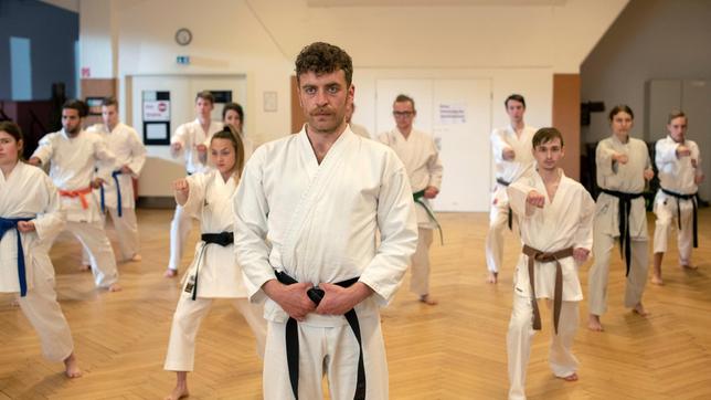 Nils Sanchez (Enrique Fiß) unterrichtet nebenbei Kinder und Jugendliche in Taekwondo (mit Niklas Post, 3.v.r. und KomparsInnen) .