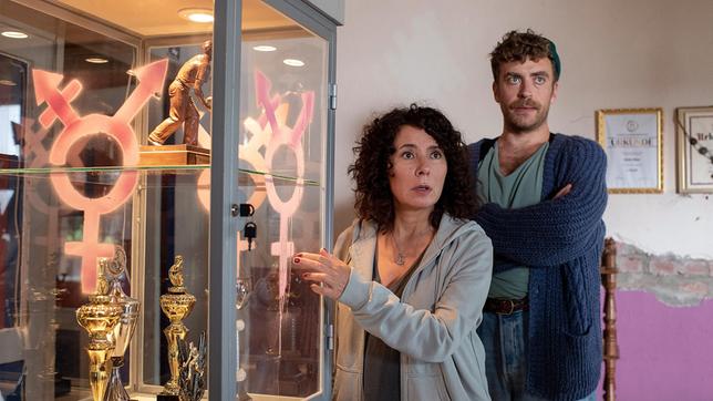 Bild: ARD/Thorsten Jander Pinker Protest: Die Vitrine im Kegelclub wurde mit dem Symbol für Diversität besprüht. Harry Möller (Maria Ketikidou) und Nils Sanchez (Enrique Fiß) sollen den Täter ausfindig machen.