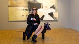 Trenchcoat, High Heels, dunkle Sonnenbrille: Frau Küppers ermittelt undercover in der Hamburger Kunstszene.