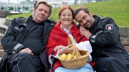 Kurze Verschnaufpause für Jan Fedder (l.), Jens Münchow (r.) und Christa Prehn, die die legendäre Hamburger Figur "Zitronen Jette" verkörpert. Im Trailer eilen ihr die beiden als Polizeibeamten Dirk Matthies und Paul Dänning zu Hilfe, als sie von Skatern über den Haufen gefahren wird