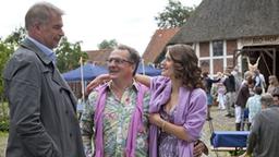 Kriminalrat Hinrichs erscheint frisch verliebt mit Melanie Meede und Jon amüsiert sich.