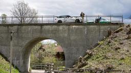 Auf einer Brücke im bayerischen Oberland entdecken Hubert (Christian Tramitz, o.) und Girwidz (Michael Brandner, im Polizeiauto) ein herrenloses Fahrzeug. Der Fahrer des Wagens Frank Giebel liegt tot am Fuß der Brücke.