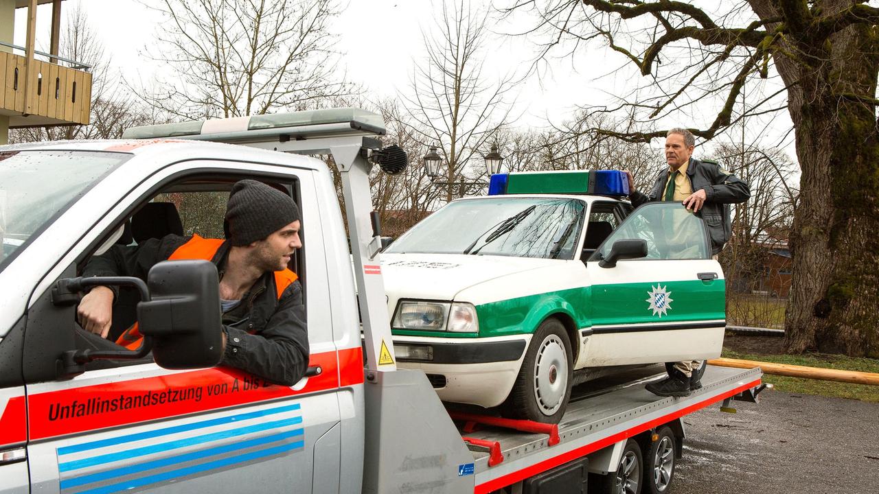 Der Streifenwagen steht im Halteverbot - Gabriel Haas (Michael Wächter) will ihn abschleppen. Hubert (Christian Tramitz) versucht das zu verhindern.