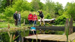 Die Leiche einer jungen Frau treibt nach einer wilden Partynacht in einem Gartenteich. Leon Schwarz (Patrick Mölleken), der Sohn des Hauses, beteuert vor Girwidz (Michael Brandner) und Hubert (Christian Tramitz, r. mit Komparsen), dass keiner den Tod der Frau bemerkt hatte.