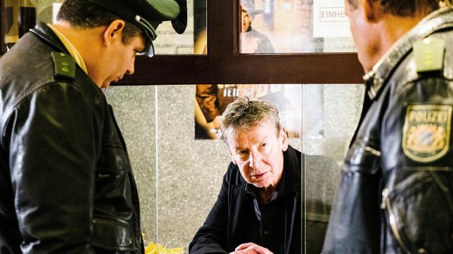 Bild: ARD/TMG/Emanuel A. Klempa Kinobesitzer Frank Henke (Michael Tregor) wird von Hubert (Christian Tramitz) und Riedl (Paul Sedlmeir) zum aktuellen Mordfall befragt.