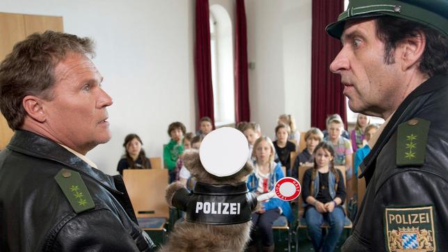 Spezialeinsatz im Schullandheim: Hubert (Christian Tramitz) und Staller (Helmfried von Lüttichau) erklären einer Schulklasse mit einer Handpuppe die Verkehrsregeln.