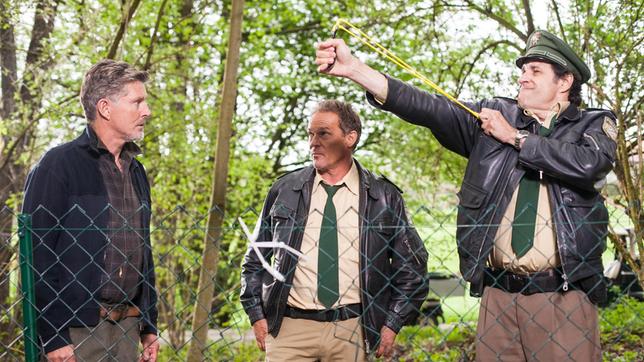 Thomas Grube (Nick Wilder) mit Hubert (Christian Tramitz) und Staller (Helmfried von Lüttichau) finden dieTatwaffe: Eine Steinschleuder.