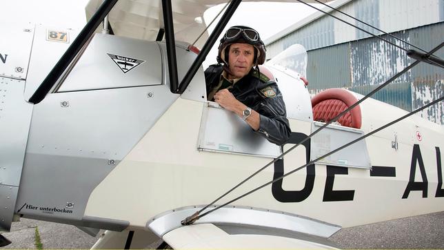 Bild: ARD/TMG/Marco Meenen Staller (Helmfried von Lüttichau) muss zwecks Spurensuche einen Rundflug im Doppeldecker über sich ergehen lassen.