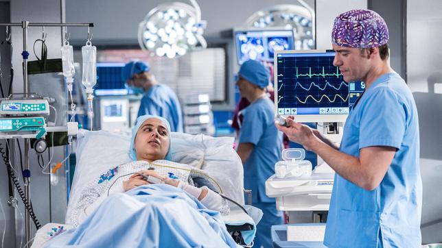Bild: ARD/Michael Kremer Die Patientin Filiz Barsani (Tua El-Fawwal, li.) bittet Ben Ahlbeck (Philipp Danne, re.), ihrem Spender vor ihrer Nierentransplantation noch etwas sagen zu dürfen (mit Komparsen).