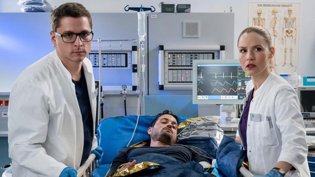 Bild: ARD/Jens-Ulrich Koch Elias Bähr (Stefan Ruppe) und Julia Berger (Mirka Pigulla) versorgen den verletzten Milo Hermann (Nicolas F. Türksever, ). In den vorangegangenen Unfall war auch dessen hochschwangere Frau Dana involviert.
