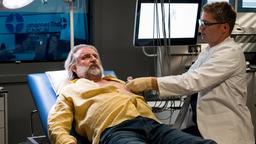 Georg Tander (Andreas Windhuis) hat auch nach der Reha noch Beschwerden. Elias Bähr (Stefan Ruppe) führt erneut Untersuchungen bei seinem ehemaligen Patienten durch.