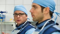 In aller Freundschaft – Die jungen Ärzte:  Elias Bähr (Stefan Ruppe) und Dr. Ahrend (Roy Peter Link) machen sich für Daniel Ruhlands Bein-OP steril.
