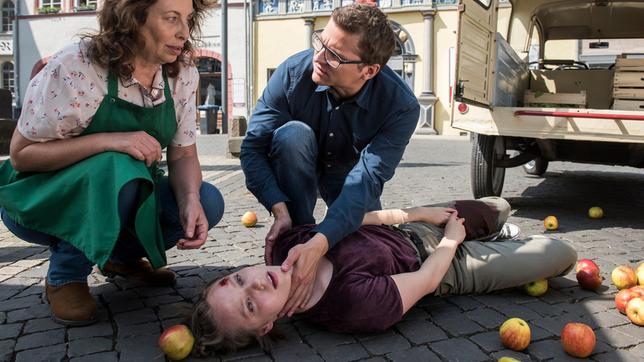 Bild: ARD/Jens-Ulrich Koch Lilly Bartosch (Emila-Rosa von Heiseler, liegend) hat sich bei einem Sturz verletzt. Ihre Chefin Martha Zoller (Teresa Harder) und Elias Bähr (Stefan Ruppe) leisten Erste Hilfe.
