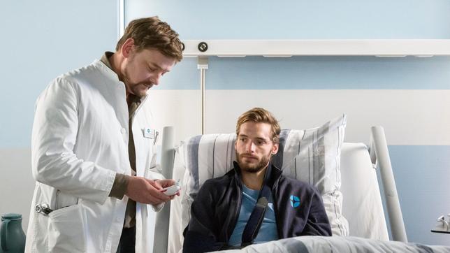 Nils Reichendorf (Vinzenz Wagner) wird nach seiner OP von Marc Lindner (Christian Beermann) untersucht. Er wurde wegen seines gebrochenen Ellbogens operiert.