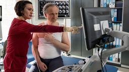 Rebecca Krieger (Milena Straube) erklärt ihrem Patienten Holger Bügel (Sebastian Weber), was auf dem Ultraschall zu sehen ist.