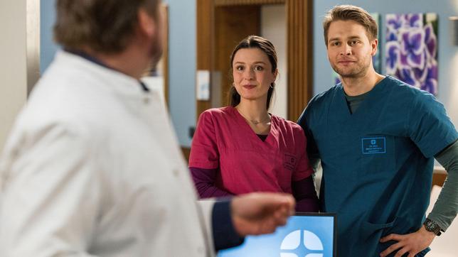 Bild: ARD/Tom Fülle Viktoria Stadler (Isabella Krieger) teilt mit Vorfreude spannende Neuigkeiten mit Mikko (Luan Gummich) und Dr. Marc Lindner (Christian Beermann).