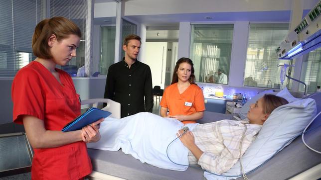 Bild: ARD/Uwe Köhn Louisa (Llewellyn Reichman) und Maxi (Leonie Rainer) kümmern sich um Tina Fischer (Charlotte Puder, liegend), die gerade eine komplizierte Entbindung hinter sich hat. Ihr Mann Karsten (Jan Dose) ist besorgt.