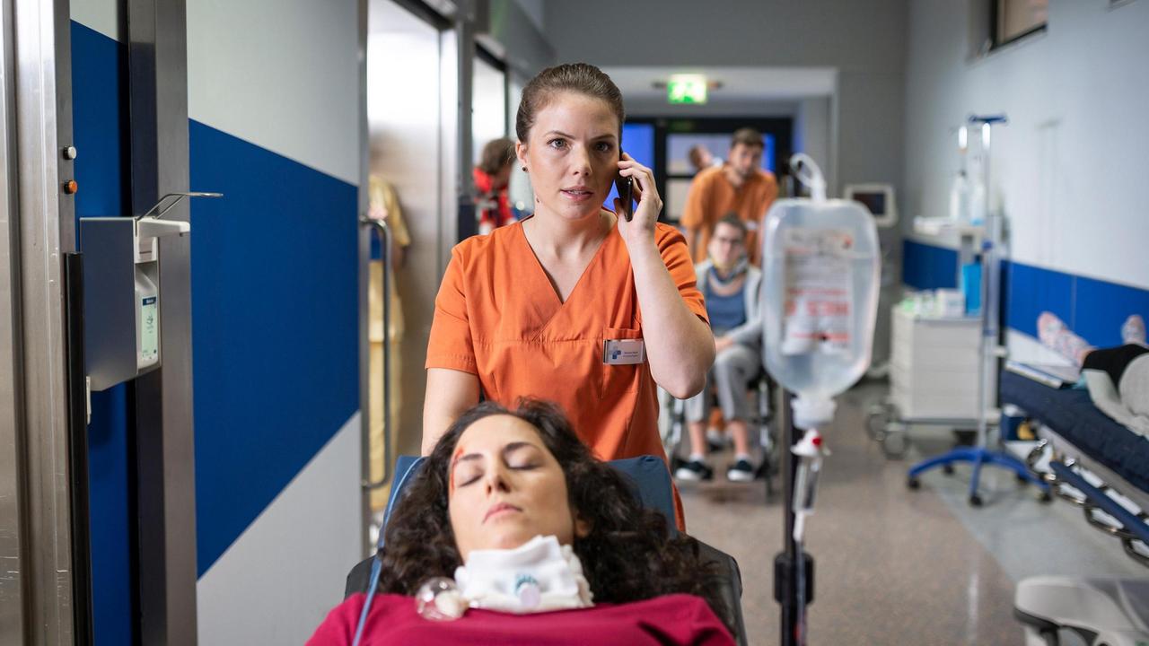 Maxi Bloch (Leonie Rainer) bekommt in der Notaufnahme eine Wachkomapatientin (Damineh Hojat, liegend), die bei einem Krankentransport in ein anderes Pflegeheim verunfallt ist und ruft Louisa Neukamm zur Hilfe.