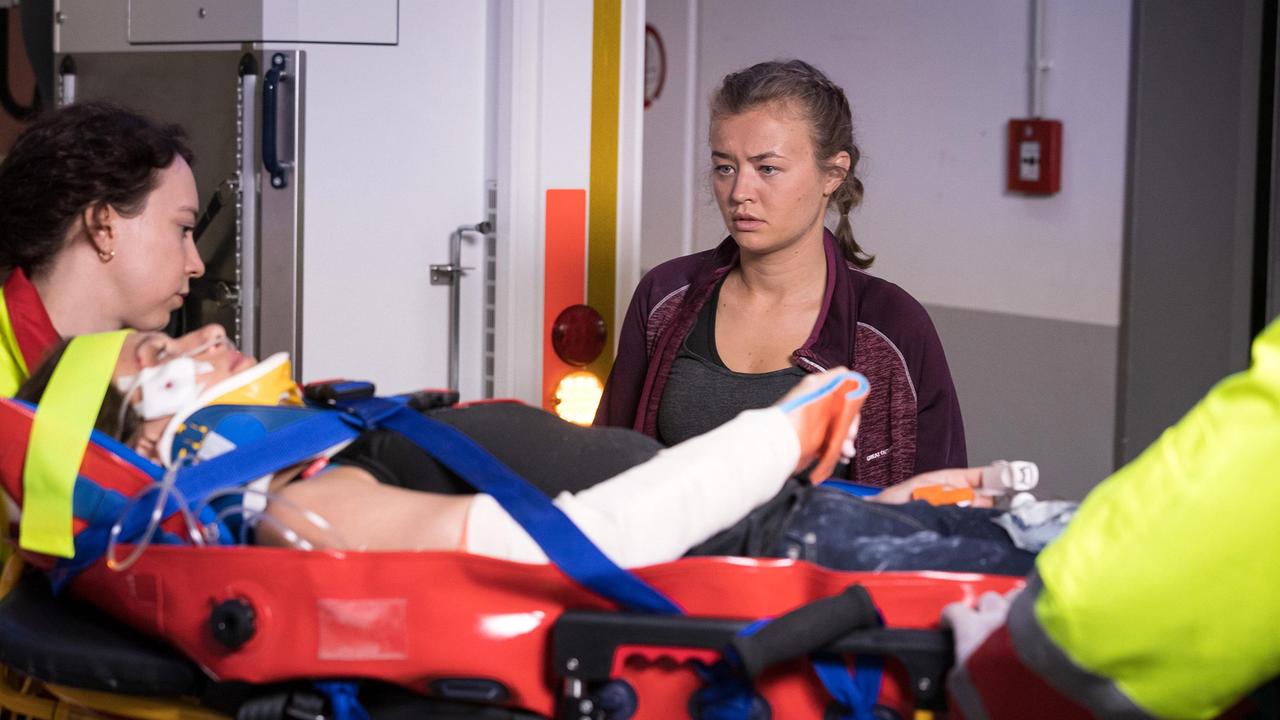 Anna Zübel (Katja Hutko, re.) begleitet ihre Schwester Finja (Eva Löser, liegend) nach einem Kletterunfall in die Sachsenklinik.