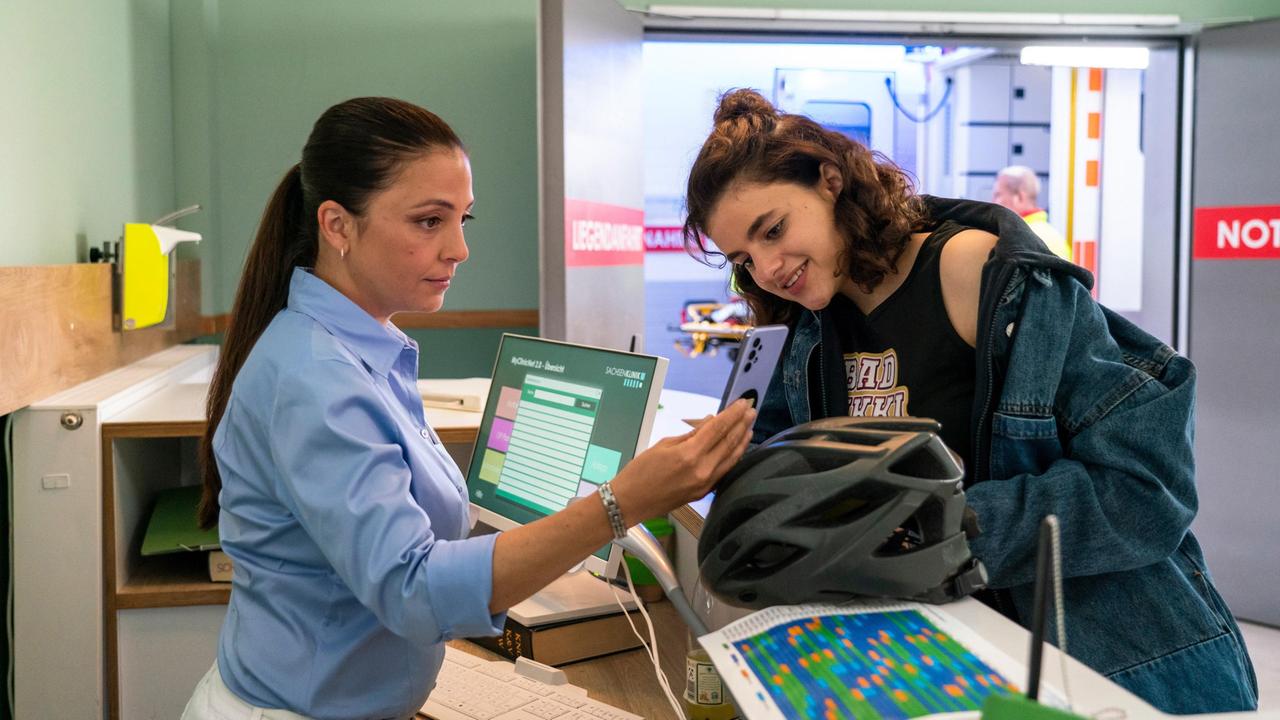 Gina Veigel (Amira Demirkiran, re.) ist auf der Suche nach ihrer Freundin "Bad Nikki", die gerade eingeliefert worden sein muss. Pflegedienstleiterin Arzu Ritter (Arzu Bazman, re.) hat noch keine Daten der Patientin, also zeigt ihr Gina ein Video von einem Wrestling-Kampf.