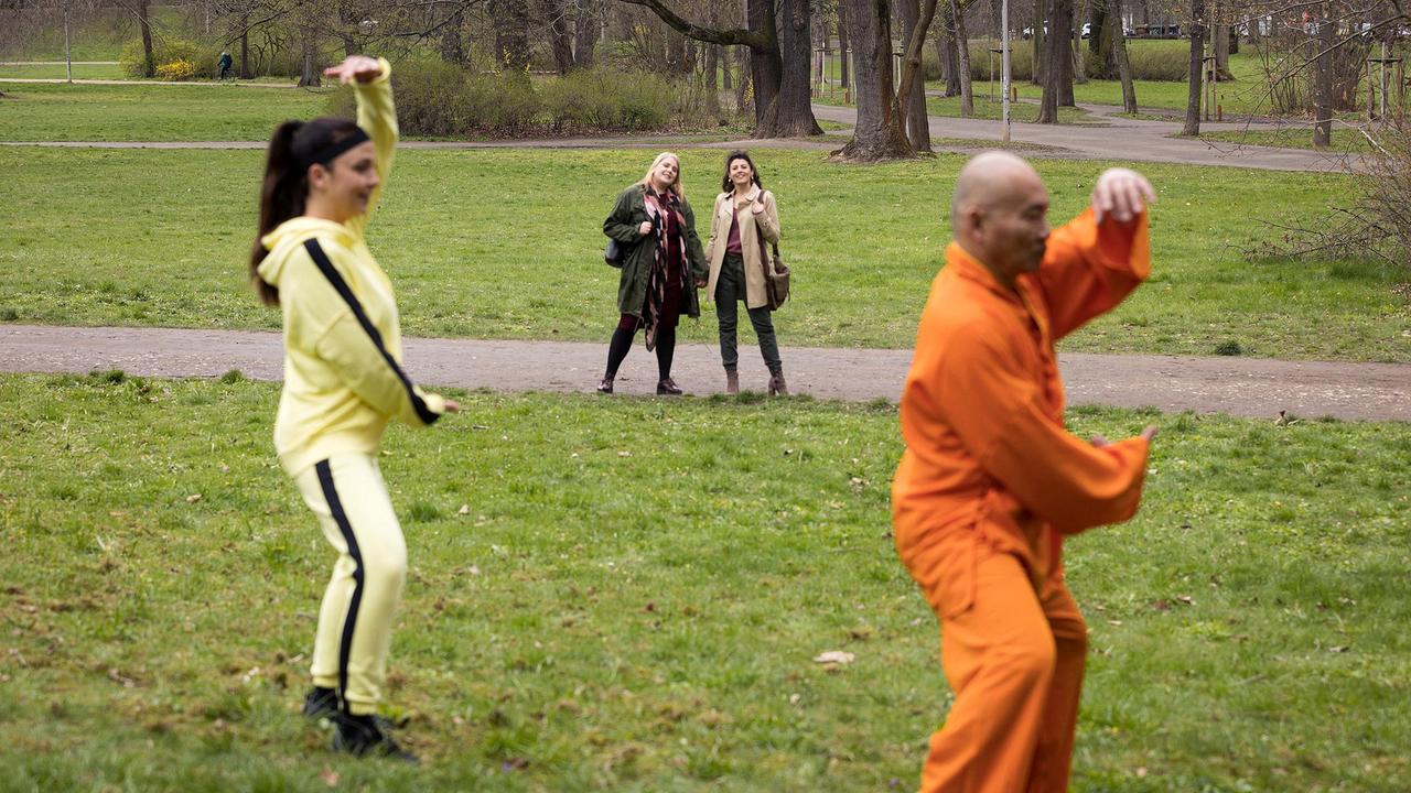 Miriam Schneider (Christina Petersen, hi.li.) und ihre zukünftige Ehefrau Rieke Machold (Liza Tzschirner, hi.re.) treffen zufällig im Park Arzu Ritter (Arzu Bazman, li.). Seitdem sie gekündigt hat, hat sie wieder mehr Zeit für sich und ihre Familie. Tai Chi mit Meister Nam (Nam Duong Hoai, re.) gehört in jedem Fall dazu.