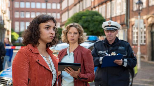 Aufgewühlt schildert Gesa Frahm (Genet Zegay) Kommissarin Tomke Jennsen (Anjorka Strechel) und einem Polizeibeamten (Komparse) den Unfallhergang.