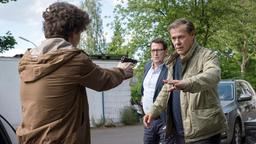 Bei einer Fahrzeugkontrolle zieht Arthur Grün (Nico Ramon Kleemann) plötzlich eine Schusswaffe und bedroht damit Lars (Ingo Naujoks) und Finn (Sven Martinek).