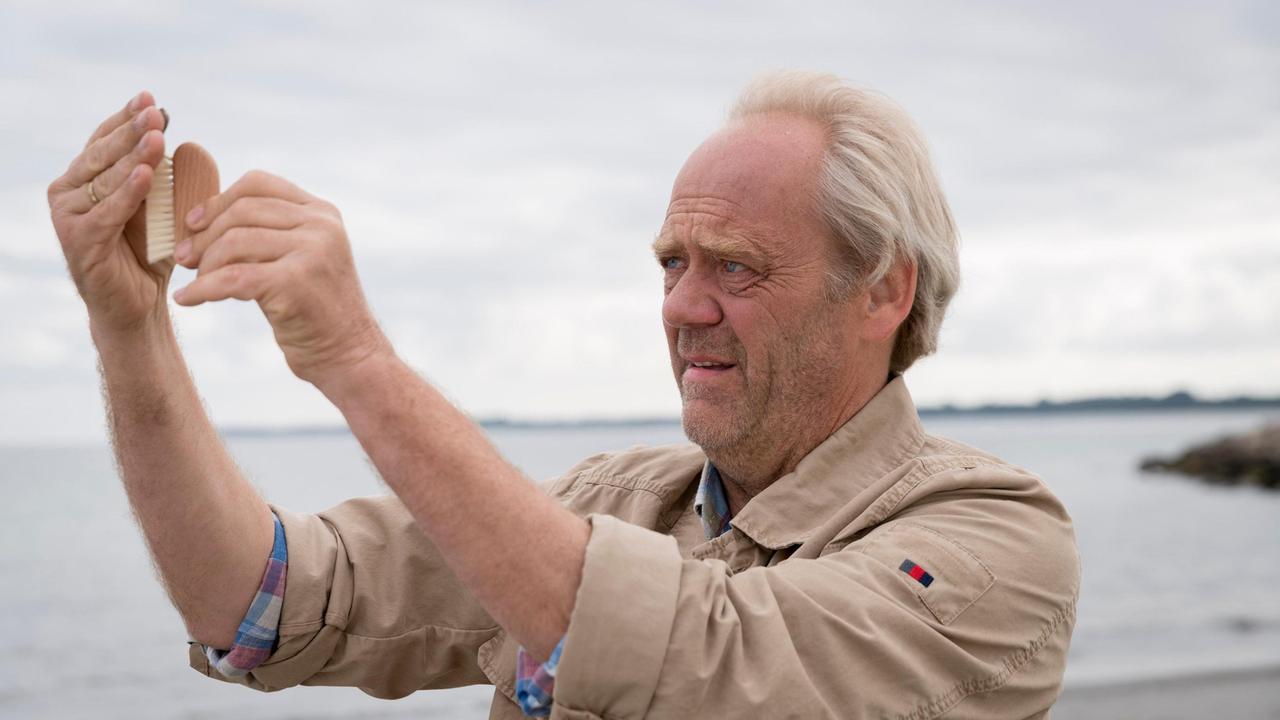 Bernsteinschleifer Enno Claasen (Hans-Heinrich Hardt) sucht am Strand nach extrem wertvollem Roh-Bernstein.