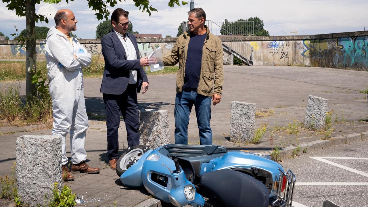 Dr. Strahl (Christoph Tomarek) informiert Lars (Ingo Naujoks) und Finn (Sven Martinek), dass der Bremsschlauch des Motorrollers manipuliert und der Vorderreifen zerstochen wurde.