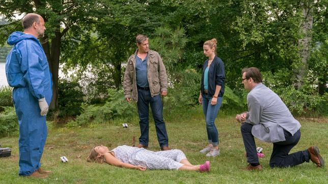 Eva Herzog wird von ihrem Ehemann mit einem Messer in der Brust im Garten gefunden. V.l.n.r. Der Pathologe Dr. Strahl (Christoph Tomanek), Finn Kiesewetter (Sven Martinek), Nina Weiss (Julia Schafle) und Lars Englen (Ingo Naujoks) stehen vor einem rätselhaften Fall.