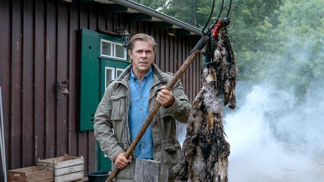 Bild: ARD/Marion von der Mehden Finn (Sven Martinek) fischt ein Wolfsfell aus den Flammen.