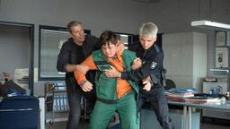 Finn Kiesewetter (Sven Martinek) hält zusammen mit einem Kollegen (Komparse) den Zeugen Oliver Wiek (Dario Redecker) fest. Oliver trägt seine Arbeitskleidung und schlägt um sich.
