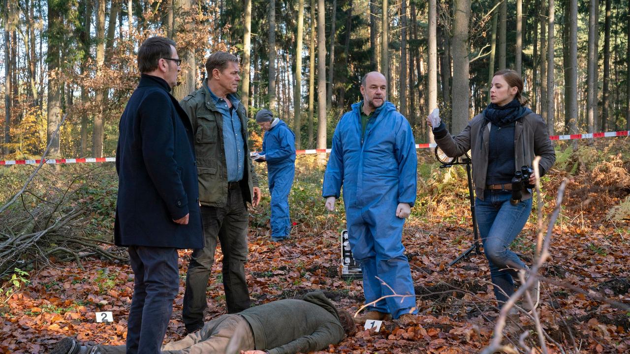 Finn Kiesewetter und Lars Englen werden im Morgengrauen an den Tatort gerufen. Ein Mann, Mitte 50, liegt tot auf einer Lichtung im Wald. Ihm wurde vermutlich aus nächster Nähe in den Hinterkopf geschossen. V.l.n.r. Lars (Ingo Naujoks), Finn (Sven Martinek), Strahl (Christoph Tomanek), Nina Weiss (Julia E. Lenska)