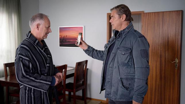 Finn (Sven Martinek) zeigt Rolf Asmus (Frank Röth) ein Foto von dem Toten. Ist dies der Mann, den er in der Nacht, nahe der Diskothek aufgegriffen hat?