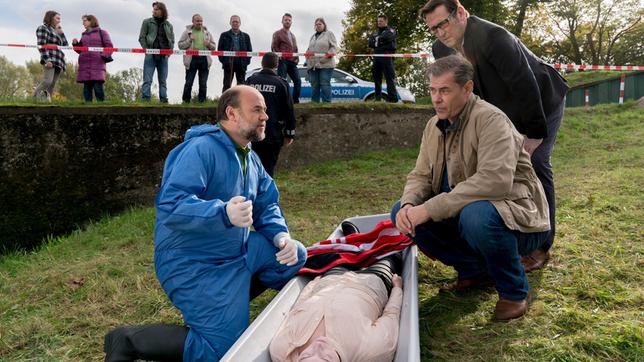 Bild: ARD/Georges Pauly Strahl (Christoph Tomanek) erörtert Finn (Sven Martinek) und Lars (Ingo Naujoks), was er bisher über die Todesumstände herausgefunden hat (mit Komparsen, h.).