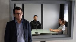 Während Ida Müller-Dogan (Amelie Plaas-Link) den Polizisten Brahmann (Karim Günes) vernimmt, hält Lars Englen (Ingo Naujoks) sich im Hintergrund.