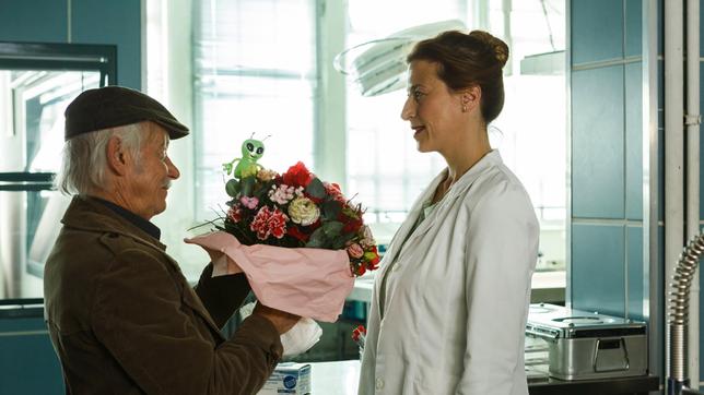 Bild: ARD/Kai Schulz Alles wieder gut? Edwin Bremer (Tilo Prückner) bringt Dr. Rosalind Schmidt (Helene Grass) einen Blumenstrauß.
