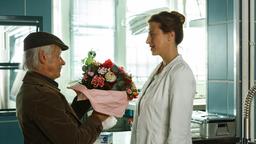 Alles wieder gut? Edwin Bremer (Tilo Prückner) bringt Dr. Rosalind Schmidt (Helene Grass) einen Blumenstrauß.