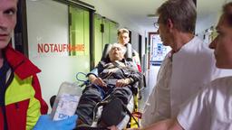 Edwin (Tilo Prückner, M. mit Komparsen) wird mit Herzproblemen ins Krankenhaus eingeliefert.
