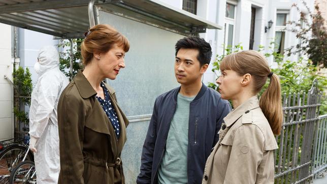 Leichenfund im Fahrradschuppen - Dr. Rosalind Schmidt (Helene Grass) informiert Hui Ko (Aaron Le) und Vicky Adam (Katja Danowski) über die seltsame Todesursache.