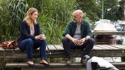 Waldemar Zwiesler (Martin Ontrop) trinkt mit Nicole Deetmers (Pauline Knof) einen Kaffee am Steg seiner Bootswerkstatt.