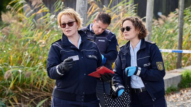 Bild: ARD/Nicolas Gradicsky Nele Fehrenbach (Floriane Daniel) und Julia Demmler (Wendy Güntensperger) sichern die Spuren am Tatort (mit Komparse).