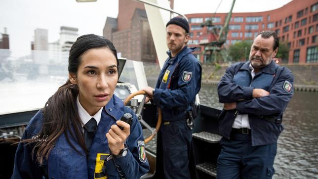 Bild: ARD/Laurent Trümper Die Polizisten Arda Turan (Yasemin Cetinkaya), Frank van Dijk (Niklas Osterloh) und Gerhard Jäger (Markus John, r. ) machen das Boot klar, da kommt ein Funkspruch.