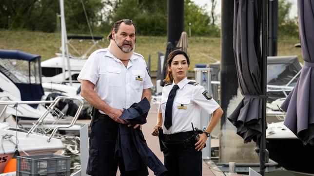 Arda Turan (Yasemin Cetinkaya) und Gerhard Jäger (Markus John) sehen sich am Jachthafen um.