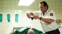 Jäger (Markus John) ist in der Mittagspause bei Dr. Reitzig, er erkennt den Toten und macht ein Foto.