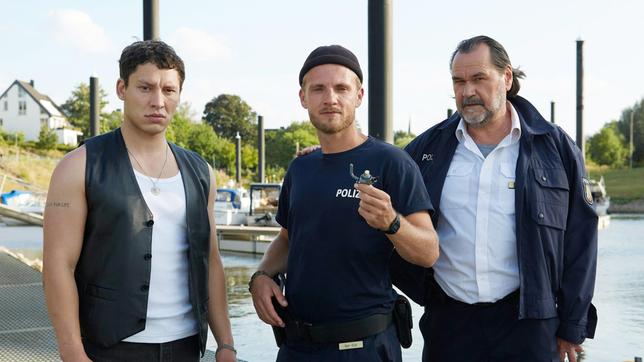 Ruben Rus (Malik Blumenthal), Frank van Dijk (Niklas Osterloh) und Gerhard Jäger (Markus John) beobachten Katjas Fluchtversuch. Doch Frank hat den Benzinhand des Jetskis in der Hand ...