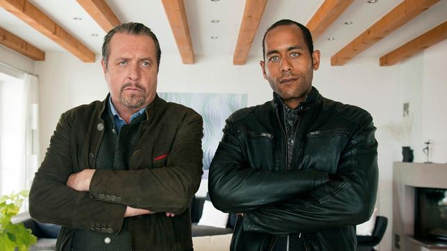 Bild: ARD/Lucky Bird Pictures/Stefanie Graul Beissl (Andreas Giebel) und Jerry (Peter Marton) sind ärgerlich, weil Klaus Leibold von dem Entführer kein Lebenszeichen von seiner Frau verlangt hat.