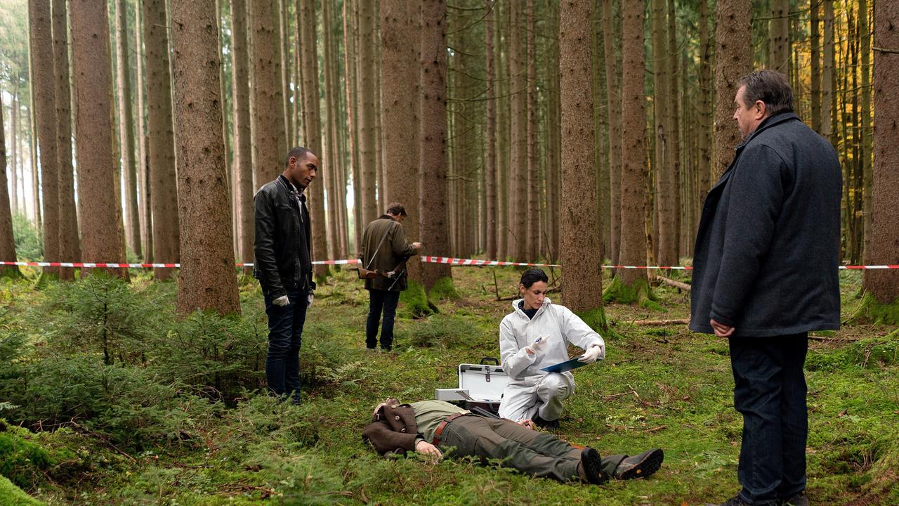 Dr. Bitterling (Genoveva Mayer) untersucht die Leiche, während die Kommissare Beissl (Andreas Giebel) und Jerry Paulsen (Peter Marton) sich am Tatort umsehen (mit Siegfried Terpoorten, h.).