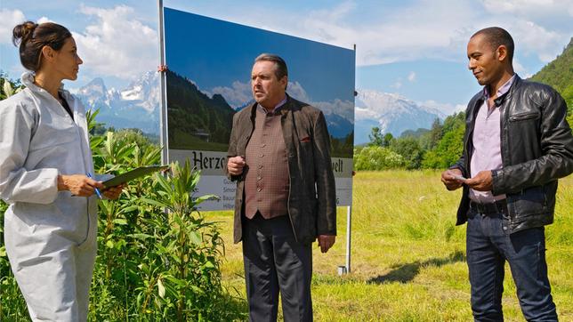Bild: ARD/Lucky Bird Pictures/Thomas Neumeier Gustl Herzog (Komparse, liegend), der Souvenirkönig von Berchtesgaden, wird erstochen aufgefunden. Beissl (Andreas Giebel), Jerry (Peter Marton) und die "Spusi" Sonja Bitterling (Genoveva Mayer) untersuchen den Tatort.
